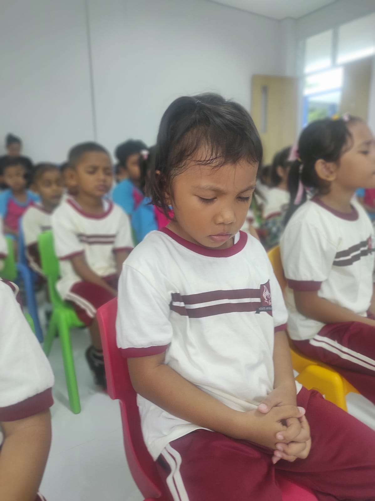 Students in uniform praying together